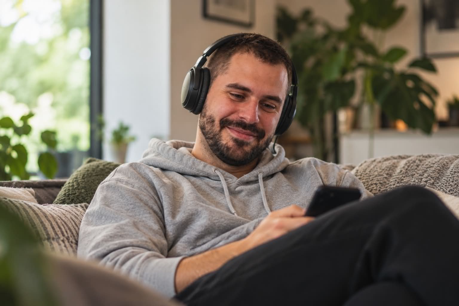 A VYVE member relaxing at home with headphones on, using the app